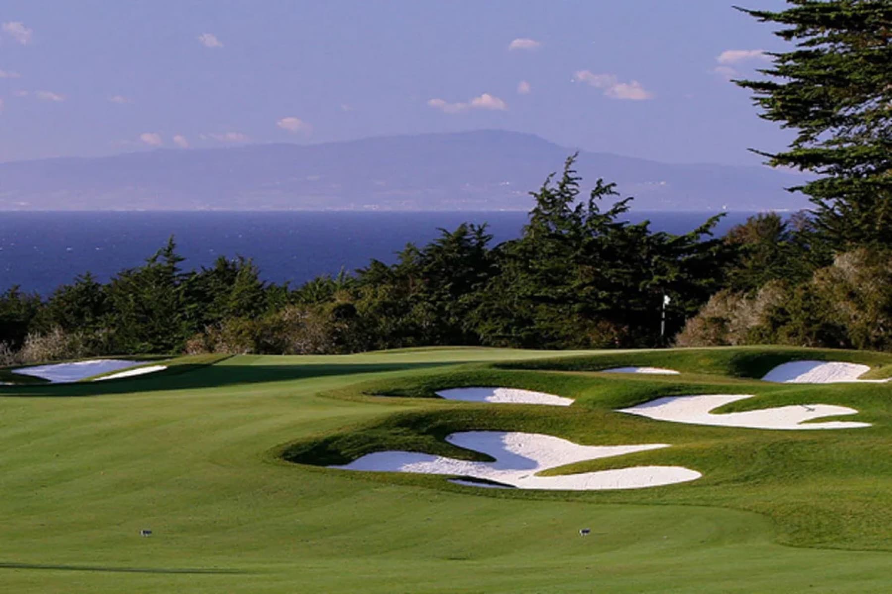 the green complex above Monterey Bay, framed by cypress and clustered bunkers
