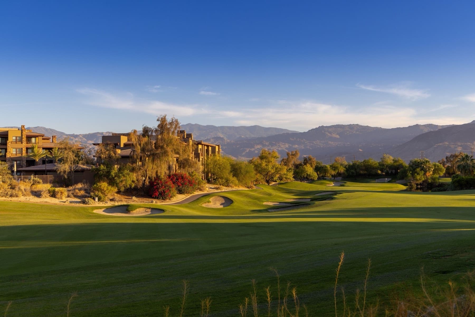 A Firecliff fairway running toward the desert villas and mountains in golden light